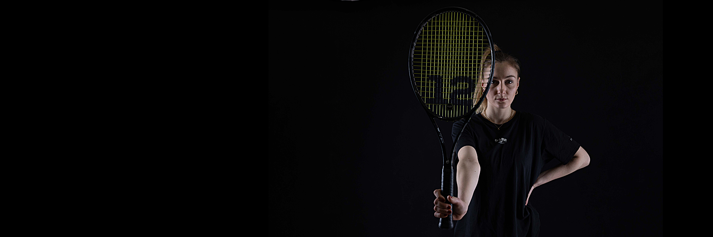 Tennisspielerin hält den Schläger nach vorne – fokussierter Blick und kontrollierte Körperhaltung